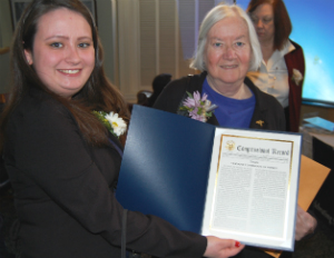 Commissioners Danielle Martel (holding Sen. Leahy's Congressional Record statement honoring VCW) and Gretchen Bailey